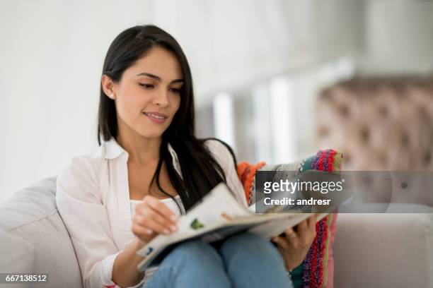 femme à la maison lisant un magazine - magazine photos et images de collection