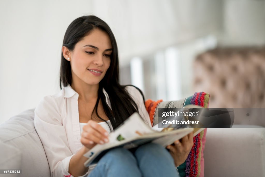 Woman at home reading a magazine