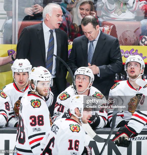 Head coach Joel Quenneville of the Chicago Blackhawks talks with assistant coach Kevin Dineen during the second period of the game against the...