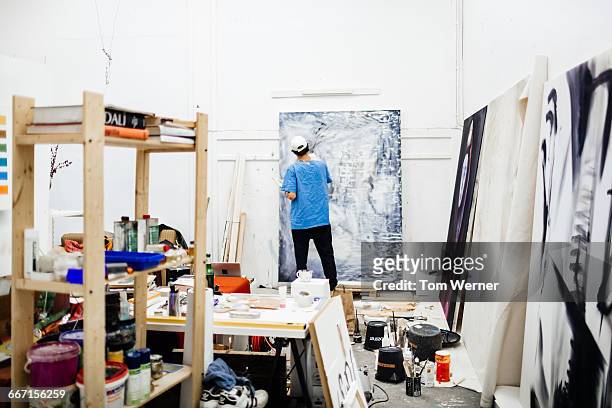 young artist working in his atelier - bildender künstler künstler stock-fotos und bilder