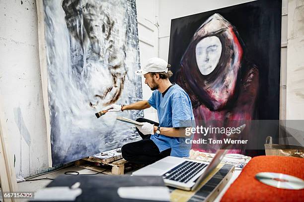 young artist working on big painting - schilder kunstenaar stockfoto's en -beelden