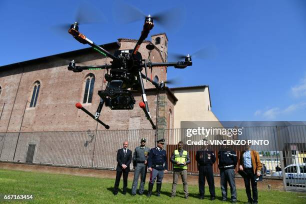 Security officers, policemen and carabinieri look at a drone equipped with a thermal camera flying to securized the area during the meeting of...