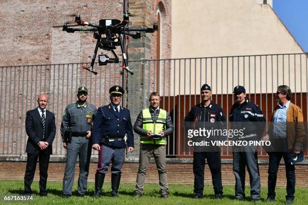 Security officers, policemen and carabinieri look at a drone equipped with a thermal camera flying to securize the area during the meeting of Foreign...