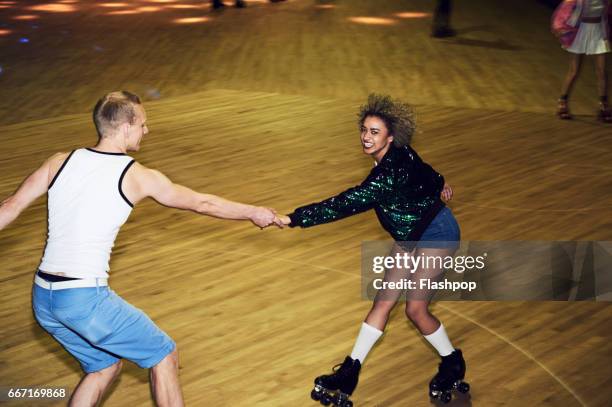 couple having fun at roller disco - roller rink stock-fotos und bilder