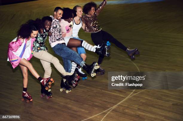 group of friends having fun at roller disco - roller rink stock-fotos und bilder