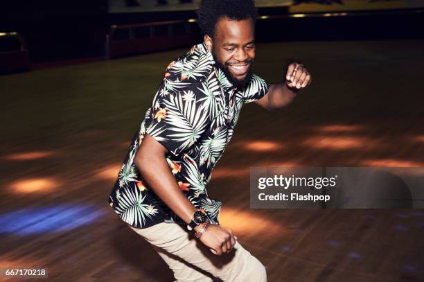 man having fun at roller disco - hawaiian shirt 個照片及圖片檔