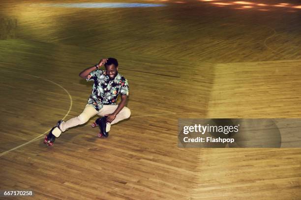 man having fun at roller disco - roller rink stock-fotos und bilder