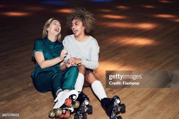 two friends having fun at roller disco - women friendship stock pictures, royalty-free photos & images