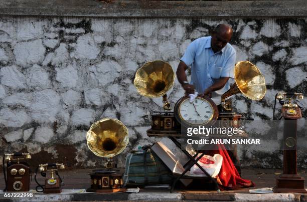 Indian vendor Mohammed Ali sets up a restored gramaphone for sale on the roadisde in Chennai on April 11, 2017. Ali, who lives in Calicut, travels...