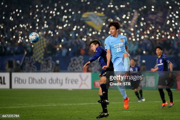 Hong Jeong-Ho of Jiangsu FC fights for the ball with Takagi Akito of Japan's Gamba Osaka during their AFC Champions League group stage football match...