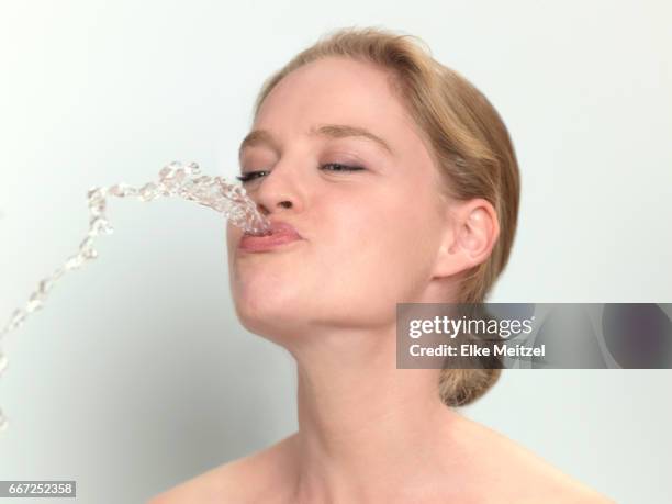 woman with water coming out of her mouth like a fountain - spats stock pictures, royalty-free photos & images