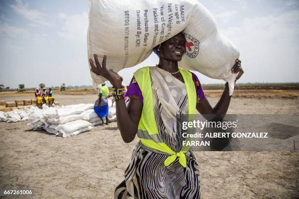 Local community volunteer carries a sack of seeds distributed by the International Committee of the Red Cross in the opposition controlled town of...