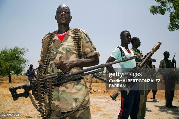 Members of the opposition troops hold weapons near their base in Thonyor, in Leer county, on April 11, 2017. At least 16 civilians were killed in...