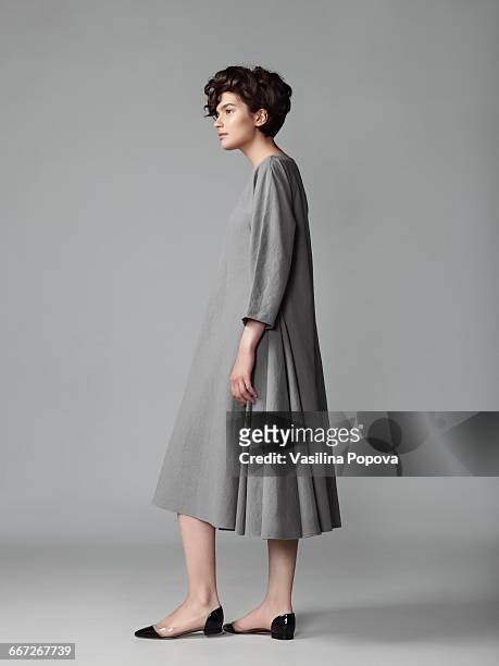 young elegant woman posing in studio - grey dress - fotografias e filmes do acervo