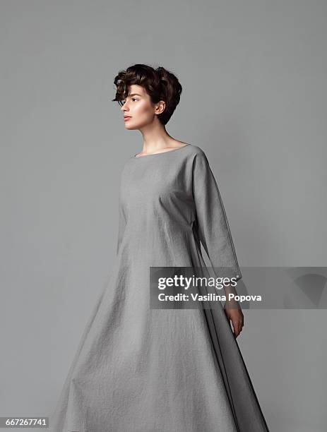 young elegant woman posing in studio - jurk stockfoto's en -beelden