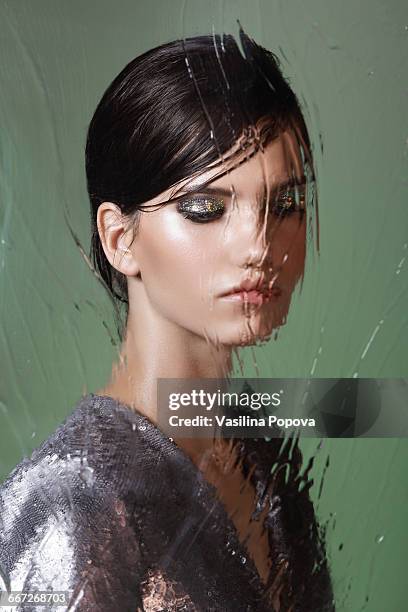 beautiful woman behind wet glass - black hair texture stock pictures, royalty-free photos & images