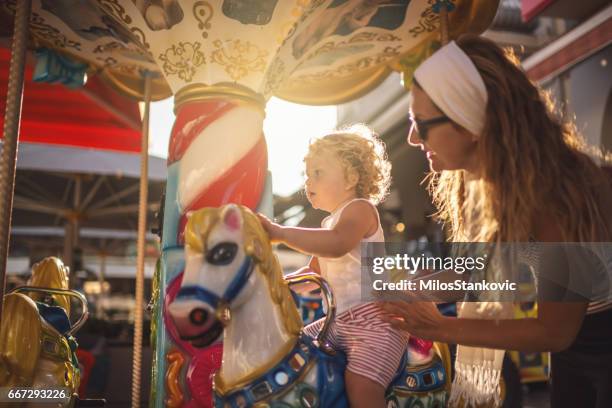 happy boy and mother on carousel - children funny moments stock pictures, royalty-free photos & images