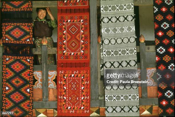 Gyem Lhamu owner of the Gonpo Tashi Yatha Weaving factory looks out from her home and factory surrounded by some of her elaborate textiles May 13,...