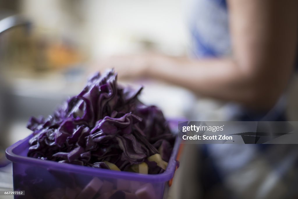 Woman in kitchen chopping vegetables