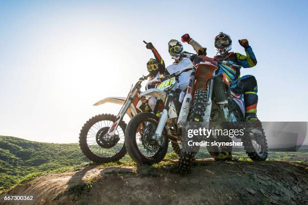 team van succesvolle motorrijder op de top van de heuvel. - motor racing track stockfoto's en -beelden
