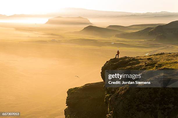 a woman hiking on a high cliff - dramatic landscape stock pictures, royalty-free photos & images