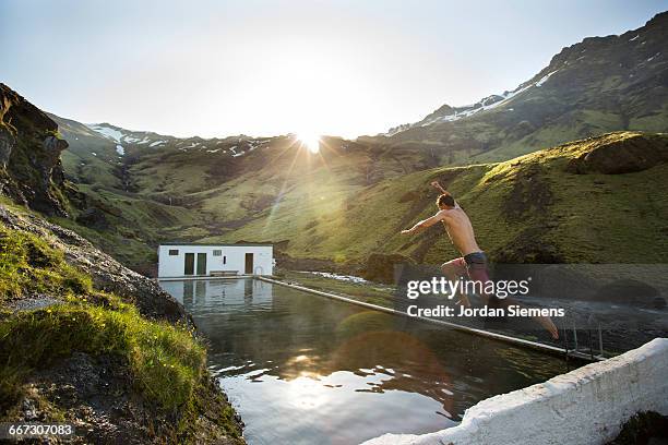 a man leaping into a hot spring. - island holiday stock-fotos und bilder