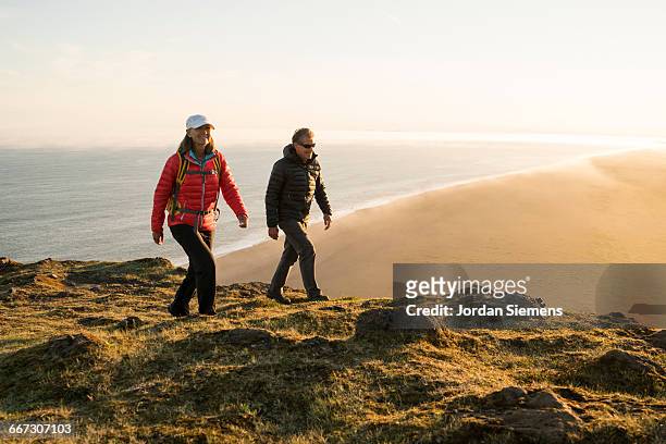 a couple hiking on a high cliff - reykjavik women stockfoto's en -beelden