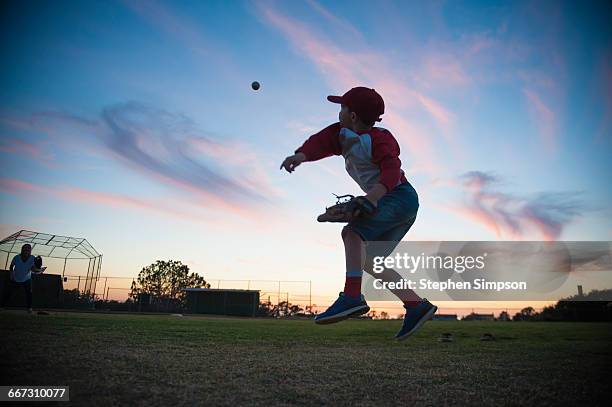 evening practice at the little league field - boy throwing stockfoto's en -beelden