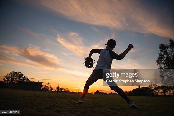 evening practice at the little league field - baseball glove silhouette stock pictures, royalty-free photos & images