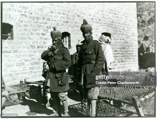 Two soldiers of the "Khyber Rifles" stand next to rope beds or "charpoys". Background to this image: With the threat of War looming in Europe, Edward...