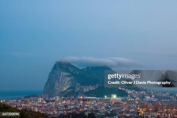 the rock of gibraltar at dusk with the levante cloud forming above it - la linea de conception stock-fotos und bilder