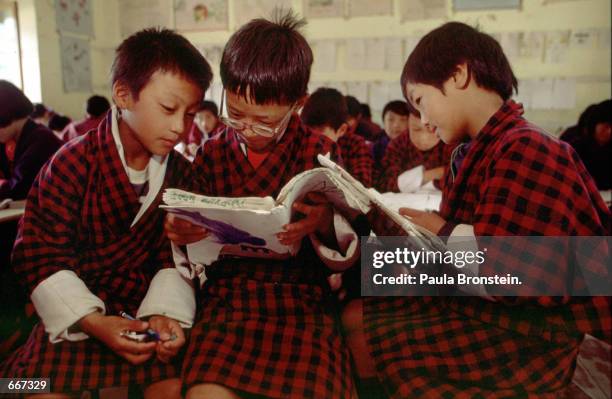 At Wangchuk Junior High School , Tshering Sonam age 10 years, Jurmin Thinley age 9, and Phurba Wansdi age 11, share notes during math class May 12,...