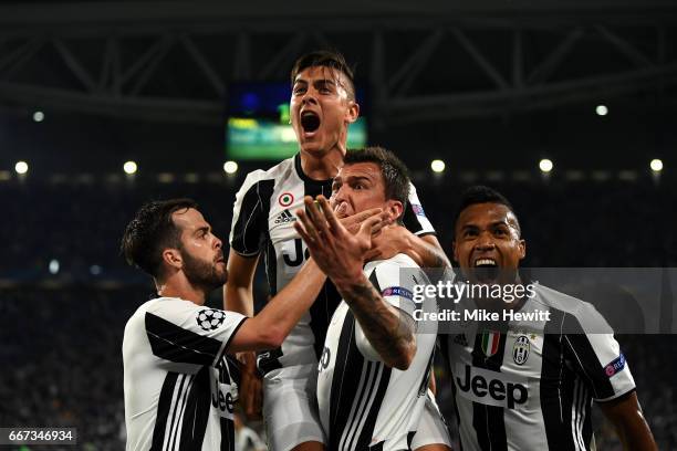 Paulo Dybala of Juventus celebrates with Miralem Pjanic, Mario Mandzukic and Alex Sandro of Juventus after scoring his team's second goal during the...