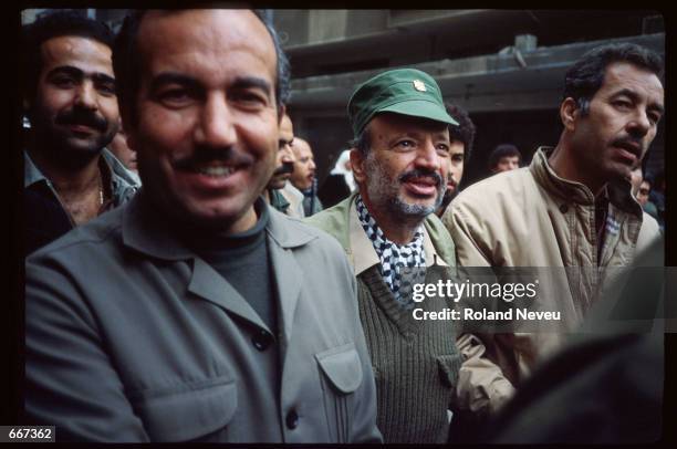 Yasser Arafat speaks while he is escorted by several men November 28, 1983 in Tripoli, Lebanon. After receiving the Nobel Peace Prize in 1994,...
