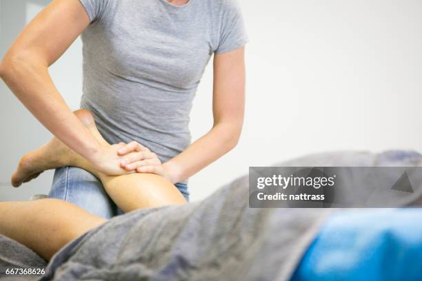female massage therapist massages a clients lower leg - calf human leg stock pictures, royalty-free photos & images