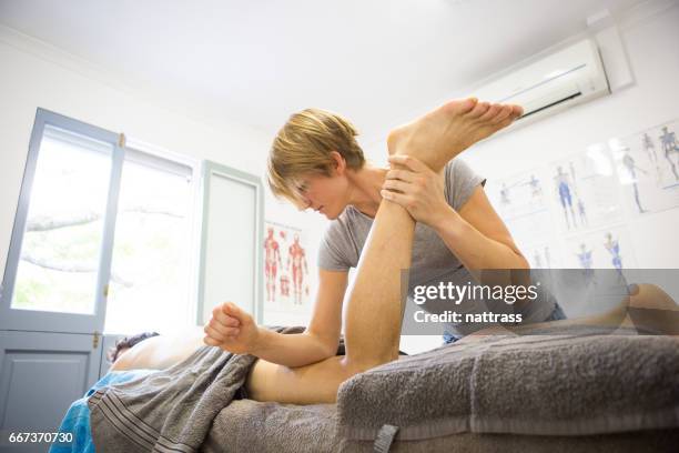 female sports massage therapist hard at work - back massage stock pictures, royalty-free photos & images