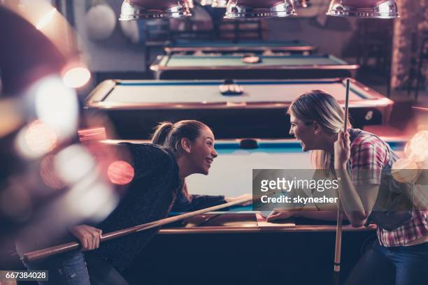 cheerful women having fun while playing billiard in a pool hall. - billiard ball game stock pictures, royalty-free photos & images