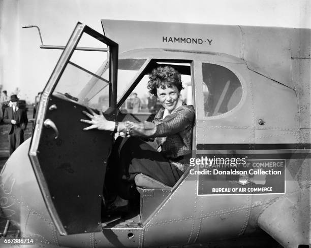 Pilot Amelia Earhart poses for a portrait in and airplane in circa 1936.