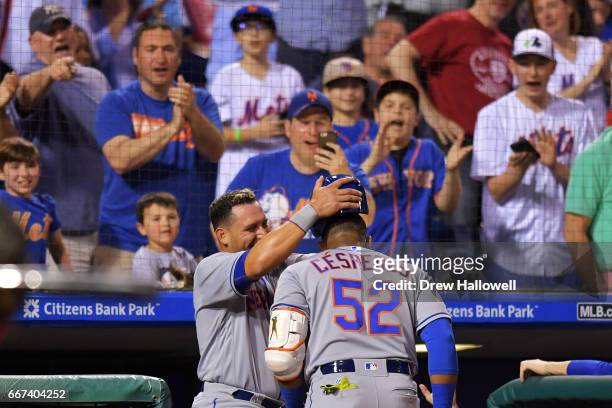Fans cheer as Asdrubal Cabrera of the New York Mets pulls the helmet off of teammate Yoenis Cespedes after hitting his second home run of the game in...