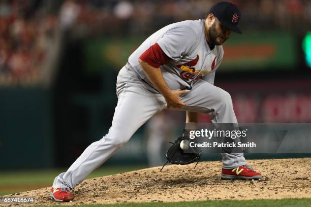 Starting pitcher Lance Lynn of the St. Louis Cardinals makes a stop on a hit by Stephen Drew of the Washington Nationals during the fifth inning at...