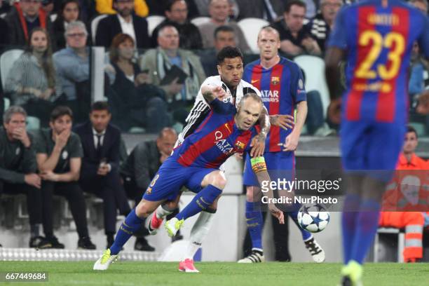 Barcelona midfielder Andres Iniesta fights for the ball against Juventus defender Dani Alves during the Uefa Champions League quarter finals football...