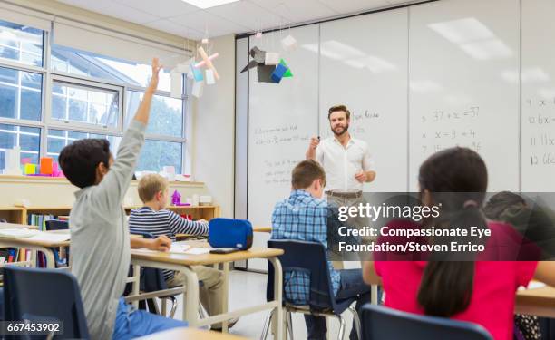 teacher with students in classroom - schoolboy stock pictures, royalty-free photos & images