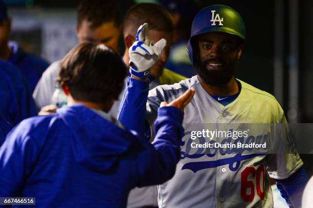 Andrew Toles of the Los Angeles Dodgers celebrates in the dugout after hitting a fifth inning solo home run against the Colorado Rockies at Coors...