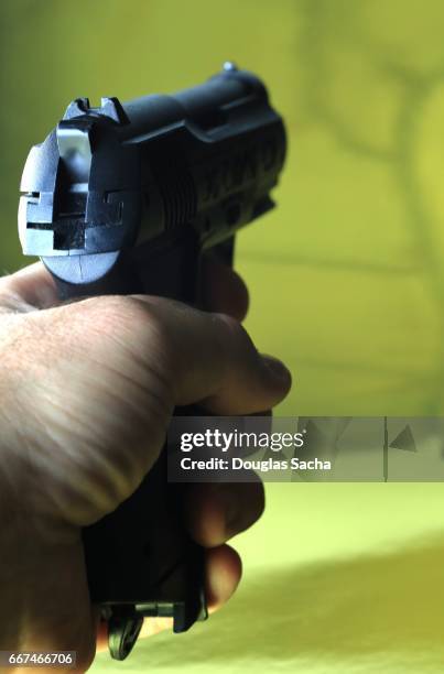 human hand aims the pistol - bank robber stock pictures, royalty-free photos & images