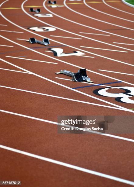 runners starting blocks on the track and field turf - estadio de atletismo fotografías e imágenes de stock