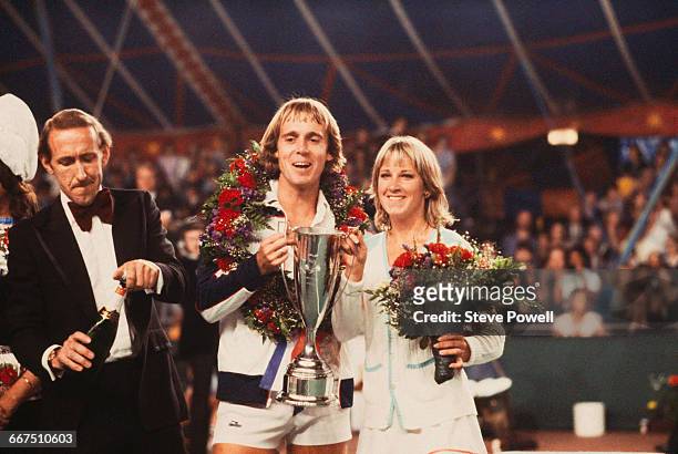English tennis player John Lloyd and his wife, American tennis player Chris Evert-Lloyd, hold the trophy after the pair won the Love Doubles charity...