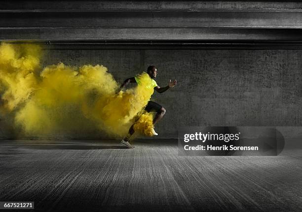 male athlete running through smoke - colored smoke stock-fotos und bilder