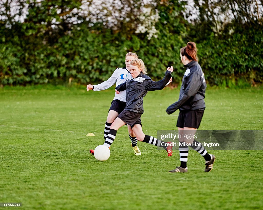 Young female footballer attempting tackle