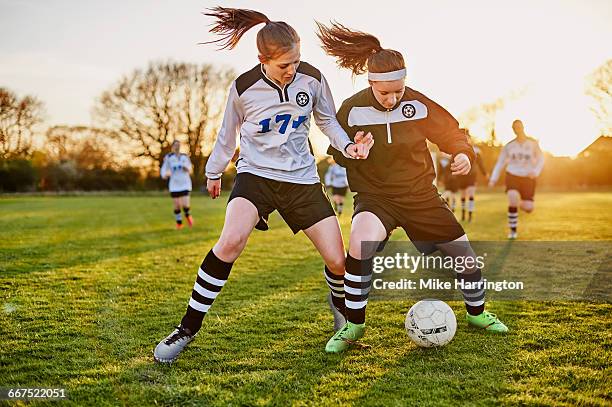 female footballers tackling - girls playing soccer stock pictures, royalty-free photos & images