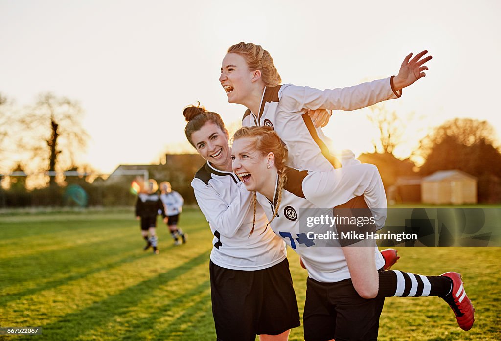 Female footballers celebrating goal